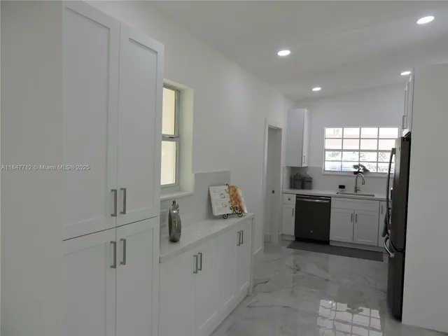 a kitchen with cabinets stainless steel appliances and a counter space