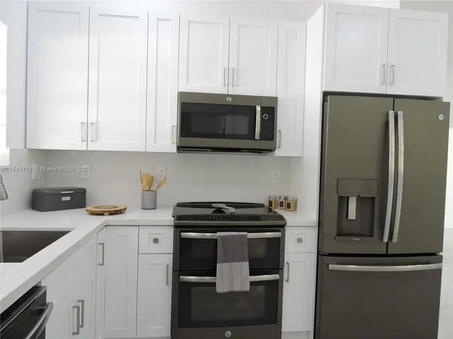 an empty room with windows and chandelier fan