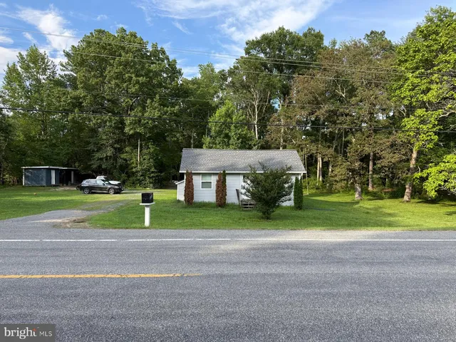 a view of a house with a big yard and large trees