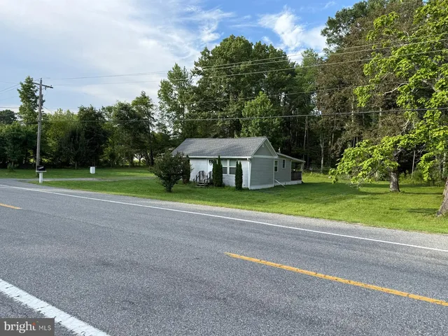 a view of a house with a big yard and large trees