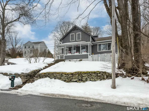 a front view of a house with a yard covered with snow