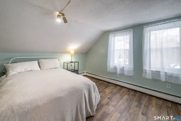 a large bed sitting in a bedroom next to a window