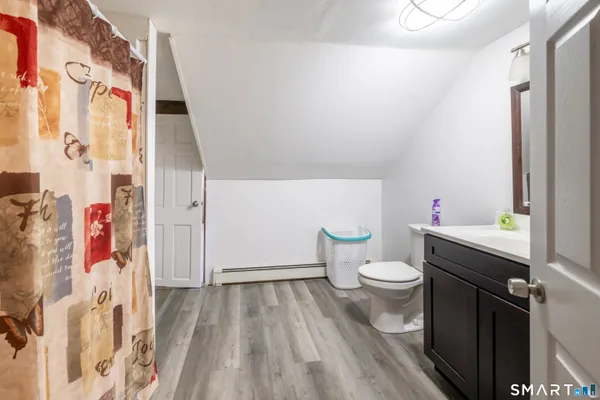 a bathroom with a white toilet sitting next to a shower curtain