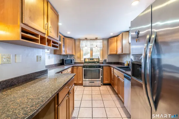 a kitchen with stainless steel appliances granite countertop a sink stove and refrigerator