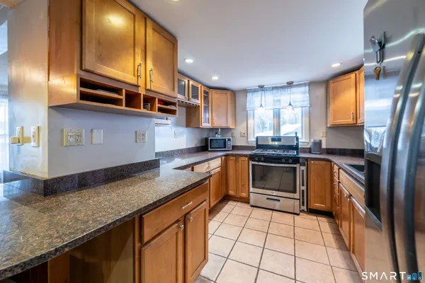 a kitchen with stainless steel appliances granite countertop a stove a sink and a microwave