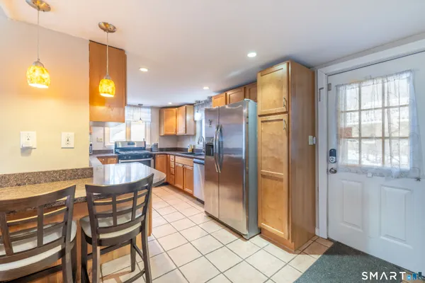 a kitchen with stainless steel appliances granite countertop a refrigerator and a stove top oven