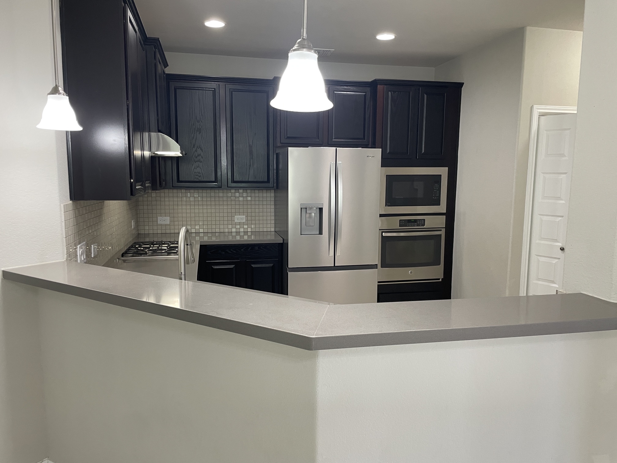 400 Hummingbird Lane, Unit A Austin, TX 78734 - Photo 4 of 31 Modern kitchen with sleek dark cabinetry and integrated stainless steel appliances.