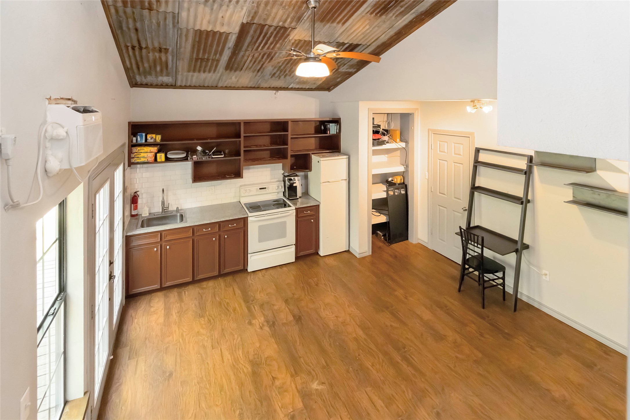 208 Old Potato Road Paige, TX 78659 - Photo 35 of 40 Apartment kitchen featuring white appliances, open, metal and wood ceiling, wood finished floors