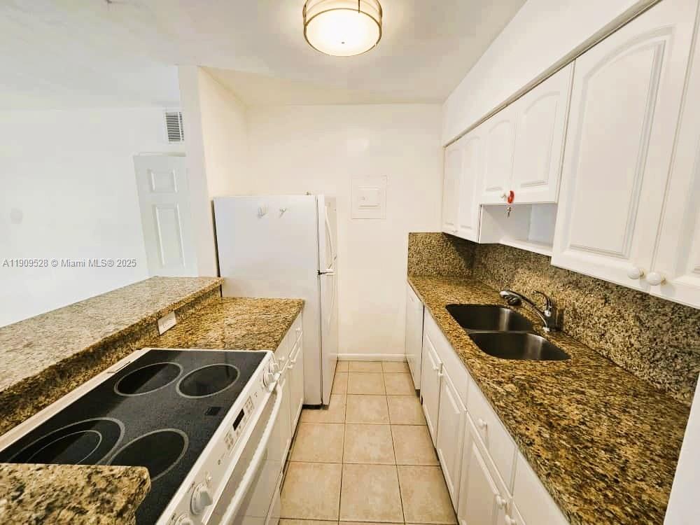3217 Northeast 7th Place, Unit 1 Pompano Beach, FL 33062 - Photo 11 of 28 a kitchen with a sink and a stove top oven