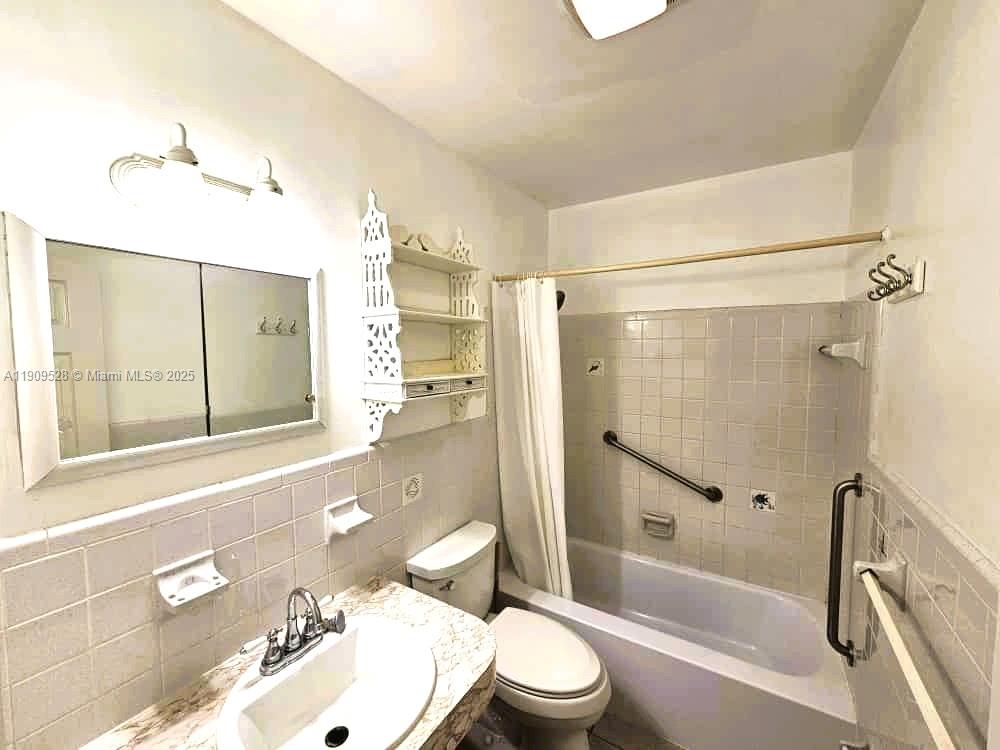 3217 Northeast 7th Place, Unit 1 Pompano Beach, FL 33062 - Photo 15 of 28 a bathroom with a bathtub shower sink vanity mirror and toilet