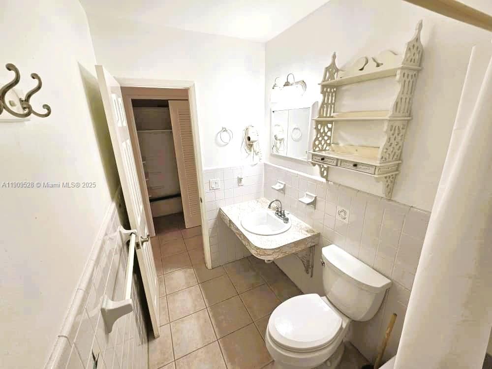 3217 Northeast 7th Place, Unit 1 Pompano Beach, FL 33062 - Photo 16 of 28 a white toilet sitting next to a bathroom sink