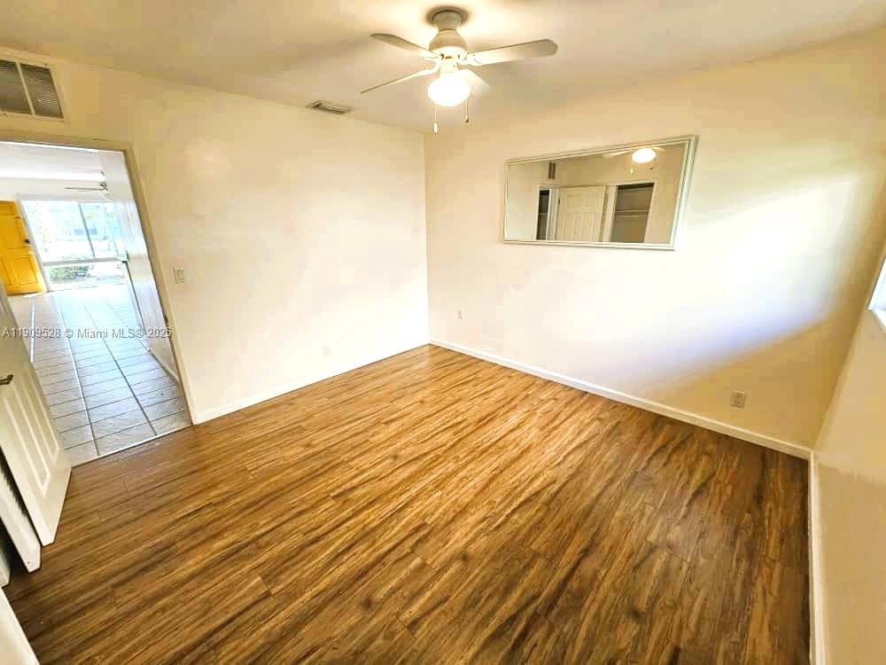 3217 Northeast 7th Place, Unit 1 Pompano Beach, FL 33062 - Photo 18 of 28 a view of a big room with wooden floor and a ceiling fan