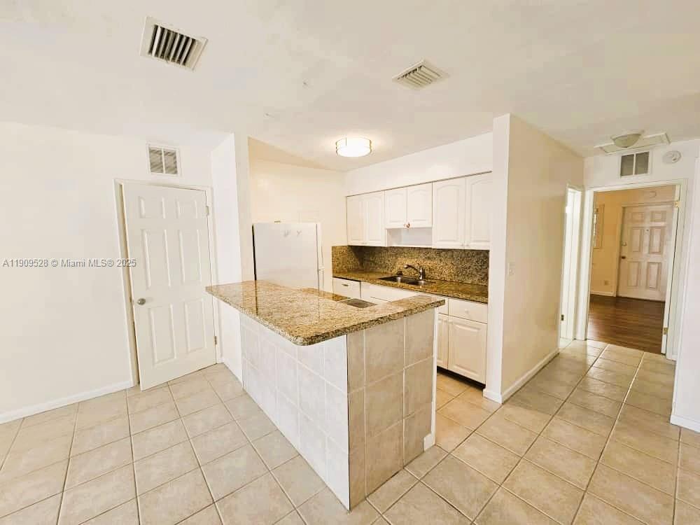 3217 Northeast 7th Place, Unit 1 Pompano Beach, FL 33062 - Photo 10 of 28 a kitchen with stainless steel appliances granite countertop a refrigerator and a stove top oven
