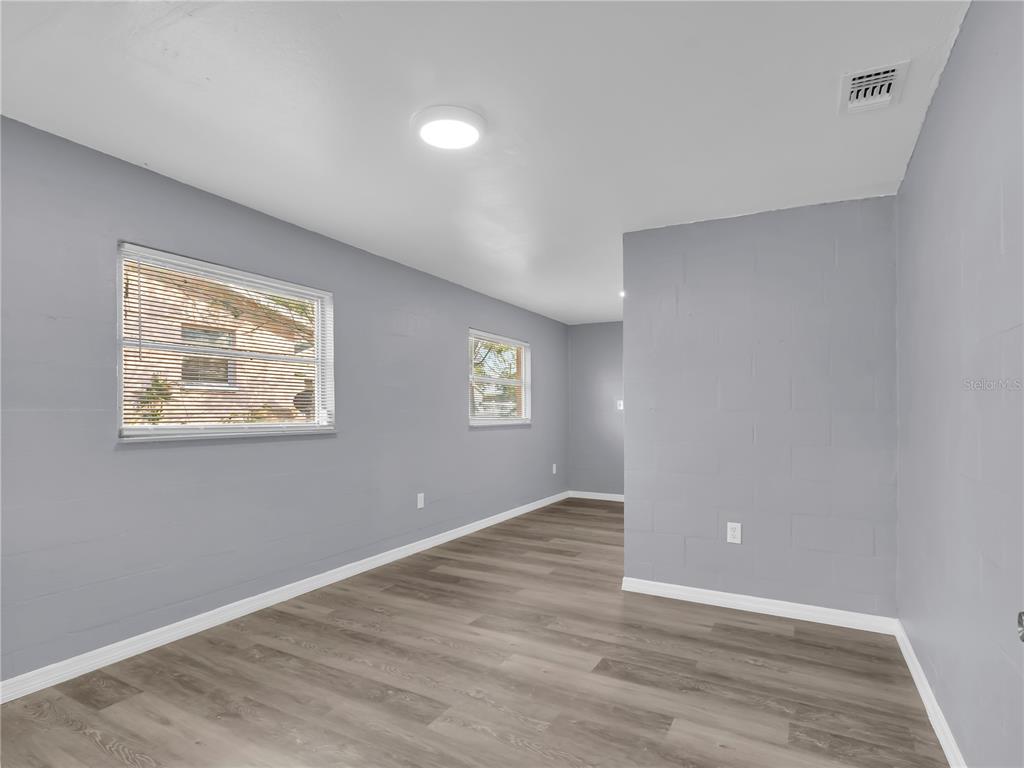 301 Southwest 3rd Terrace Mulberry, FL 33860 - Photo 16 of 39 a view of an empty room with wooden floor and a window