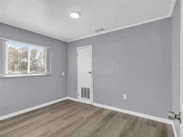 a view of empty room with wooden floor