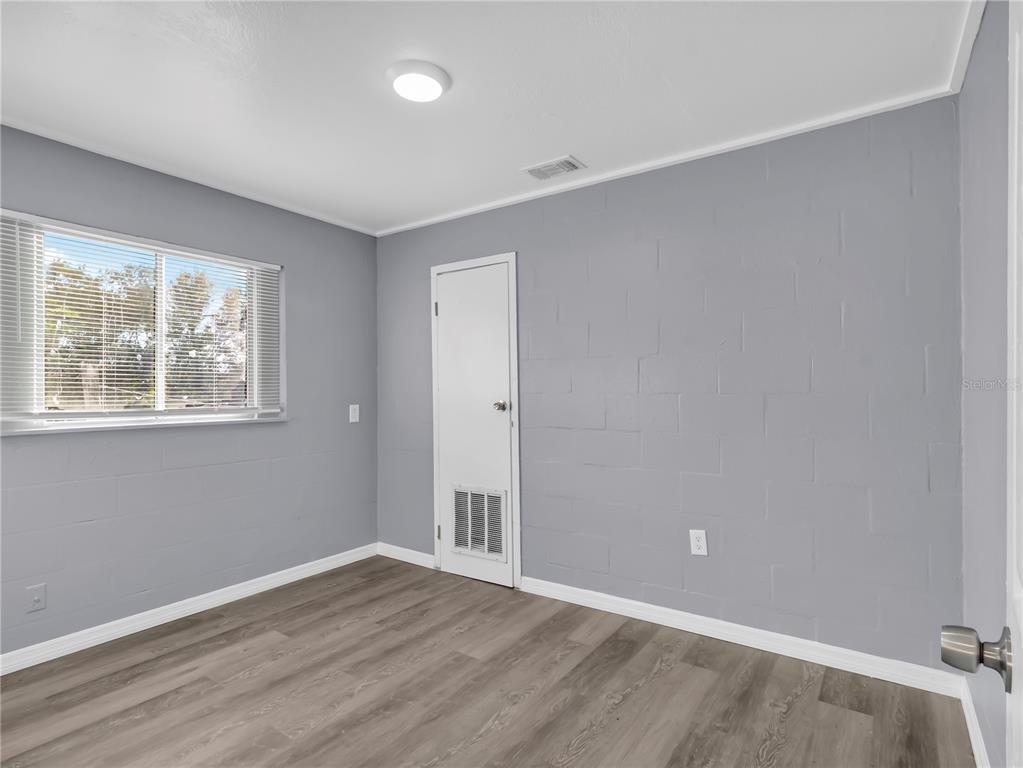 301 Southwest 3rd Terrace Mulberry, FL 33860 - Photo 22 of 39 a view of an empty room with wooden floor and a window