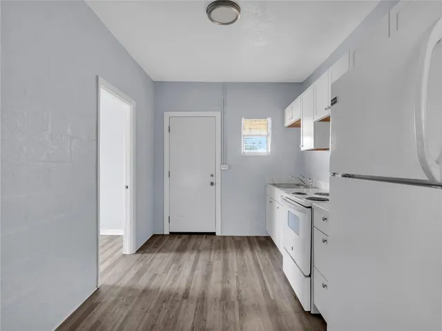 a kitchen with a sink cabinets and wooden floor