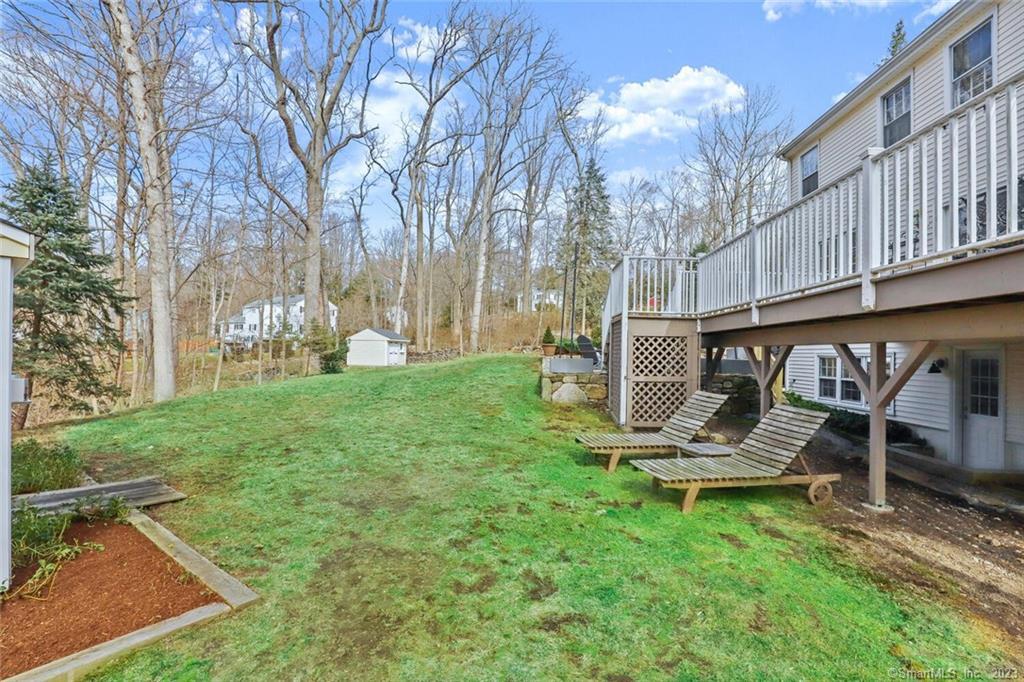 183 Frogtown Road New Canaan, CT 06840 - Photo 31 of 37 a view of a chair and table in backyard of the house