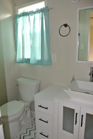 a bathroom with a sink a toilet and a mirror