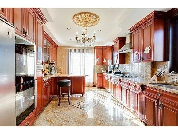 a kitchen with stainless steel appliances granite countertop a stove top oven a sink a dining table and chairs