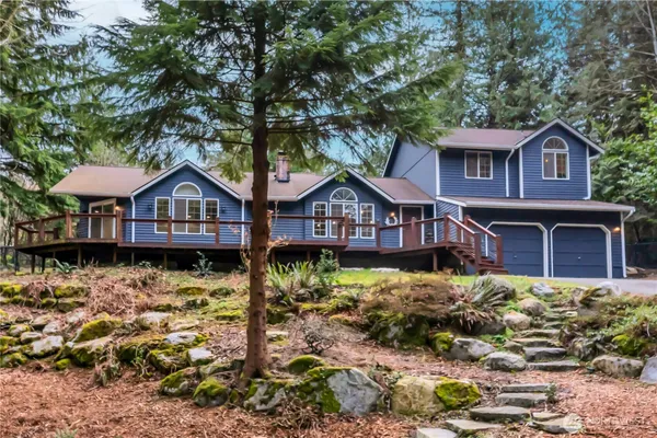 a front view of a house with yard garage and wooden deck