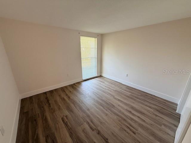 600 Russell Street Longboat Key, FL 34228 - Photo 10 of 13 a view of an empty room with wooden floor and a window