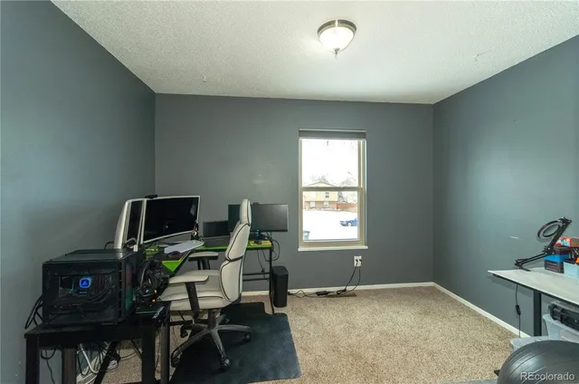a view of a workspace with furniture and a window