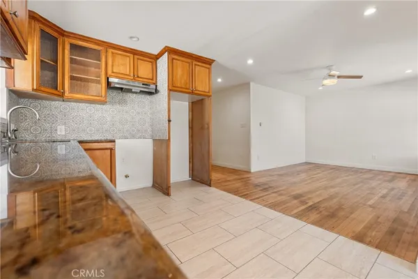 an empty room with windows and ceiling fan