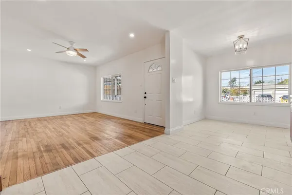 a view of a hallway with wooden floor and a bathroom