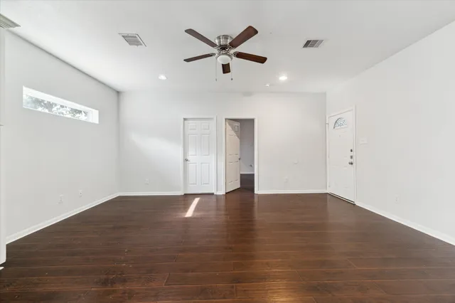 a view of an empty room with ceiling fan