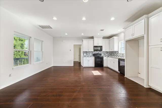a view of kitchen with stove and cabinets