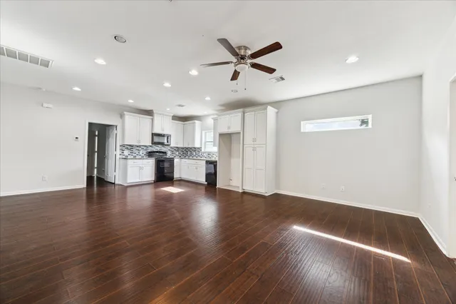 a view of empty room with wooden floor and window