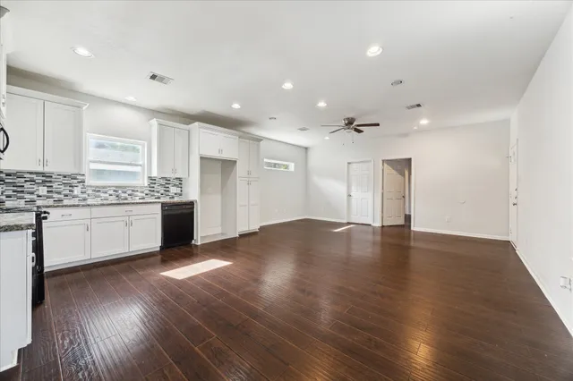 a view of kitchen with granite countertop stainless steel appliances refrigerator sink and cabinets