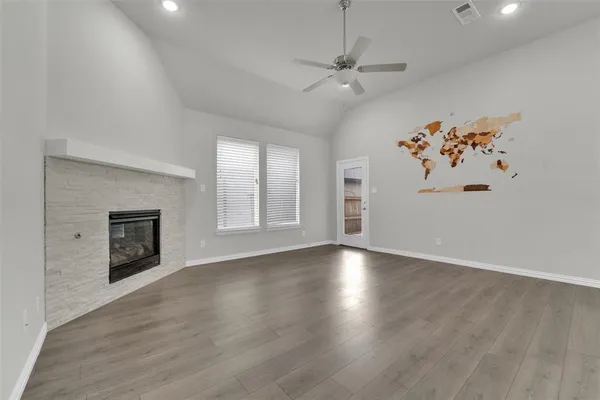 an empty room with windows and fireplace