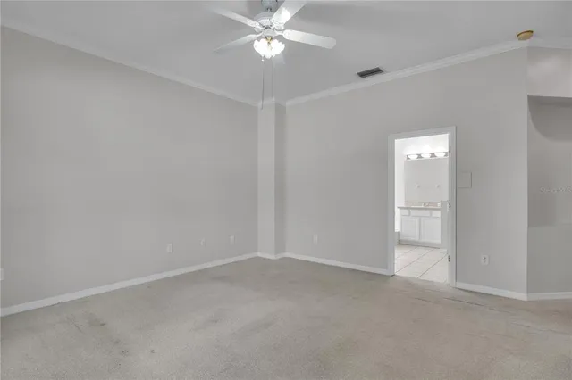 an empty room with a chandelier fan and closet area