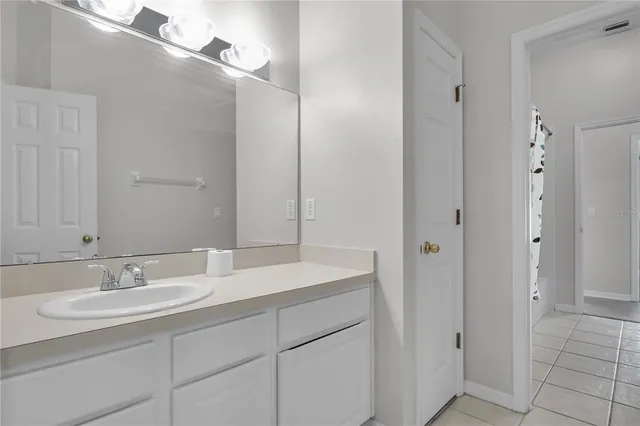 an empty room with a windows and chandelier fan