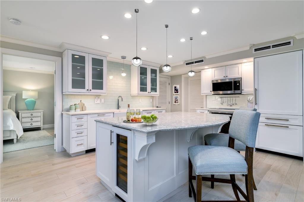 a kitchen with white cabinets and chairs