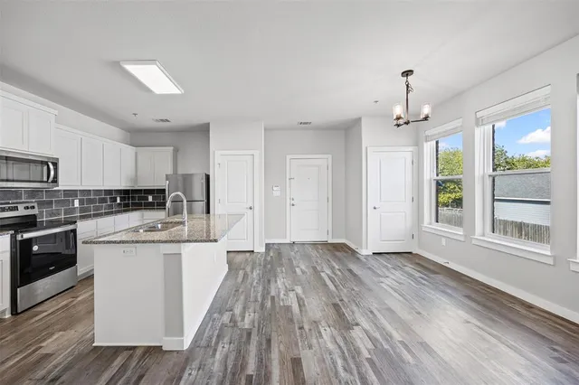 a kitchen with stainless steel appliances granite countertop a stove and a sink