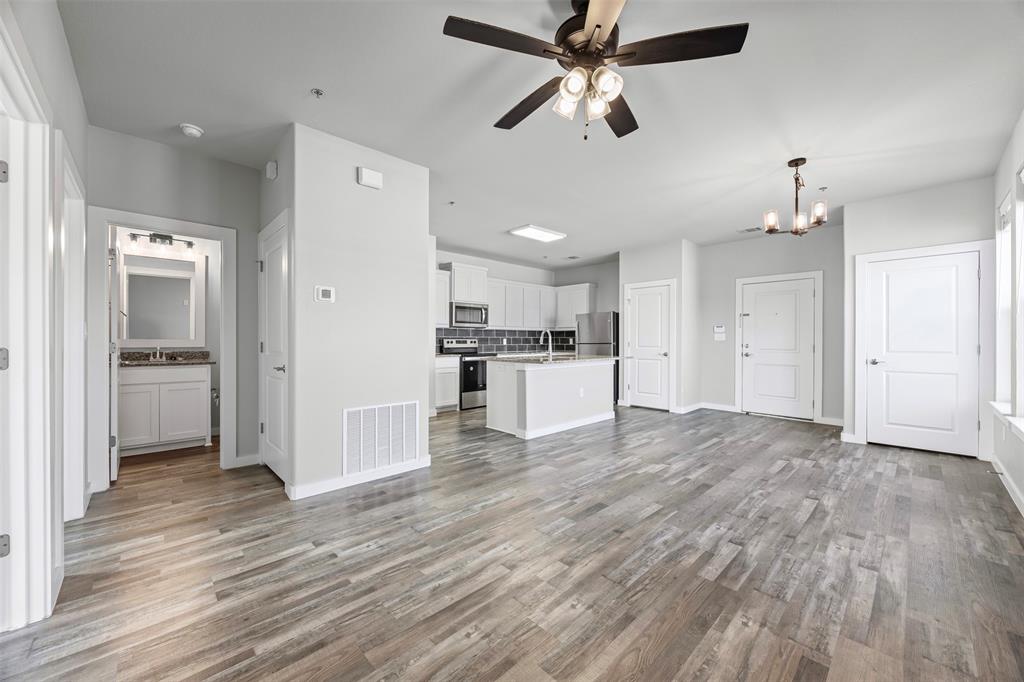 201 East 5th Street, Unit 201 Ferris, TX 75125 - Photo 12 of 19 a view of a kitchen with a refrigerator and a wooden floor