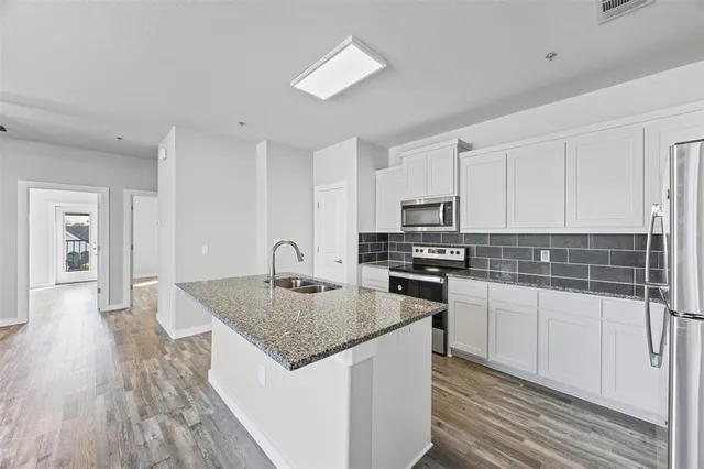 a kitchen with stainless steel appliances granite countertop a refrigerator and a sink