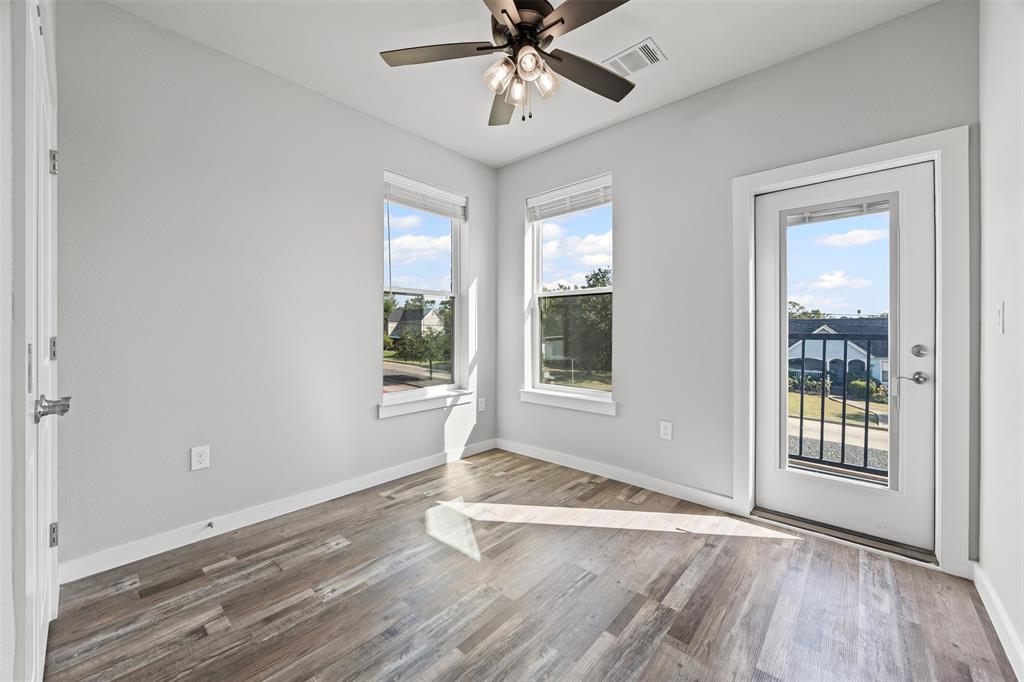 201 East 5th Street, Unit 201 Ferris, TX 75125 - Photo 16 of 19 an empty room with wooden floor chandelier and windows