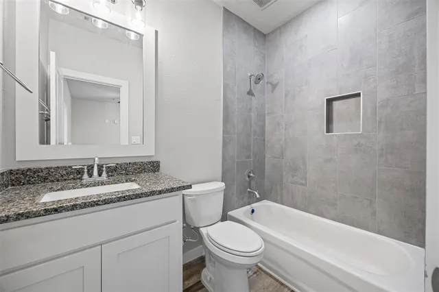 an empty room with wooden floor chandelier and windows