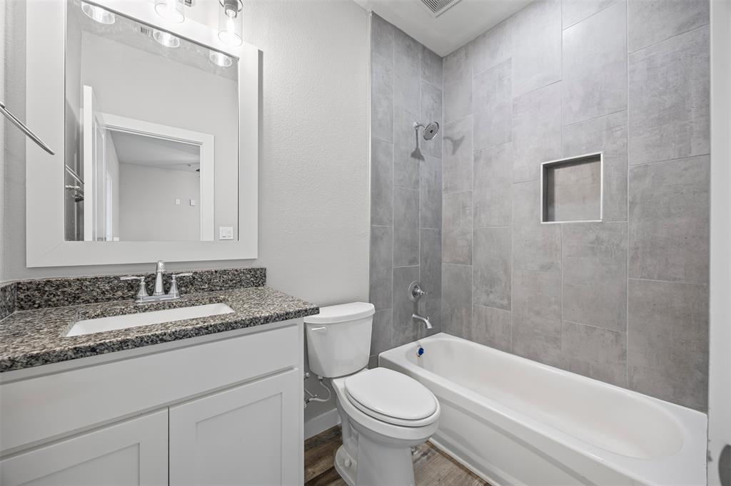 201 East 5th Street, Unit 201 Ferris, TX 75125 - Photo 17 of 19 a bathroom with a granite countertop sink toilet and shower