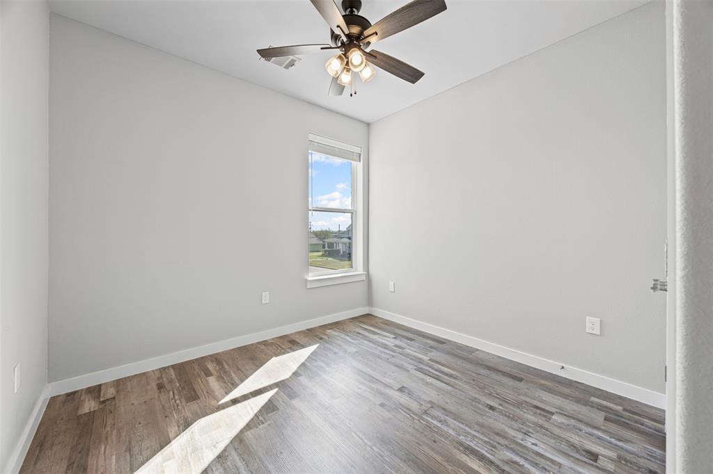 201 East 5th Street, Unit 201 Ferris, TX 75125 - Photo 18 of 19 wooden floor in an empty room with a window