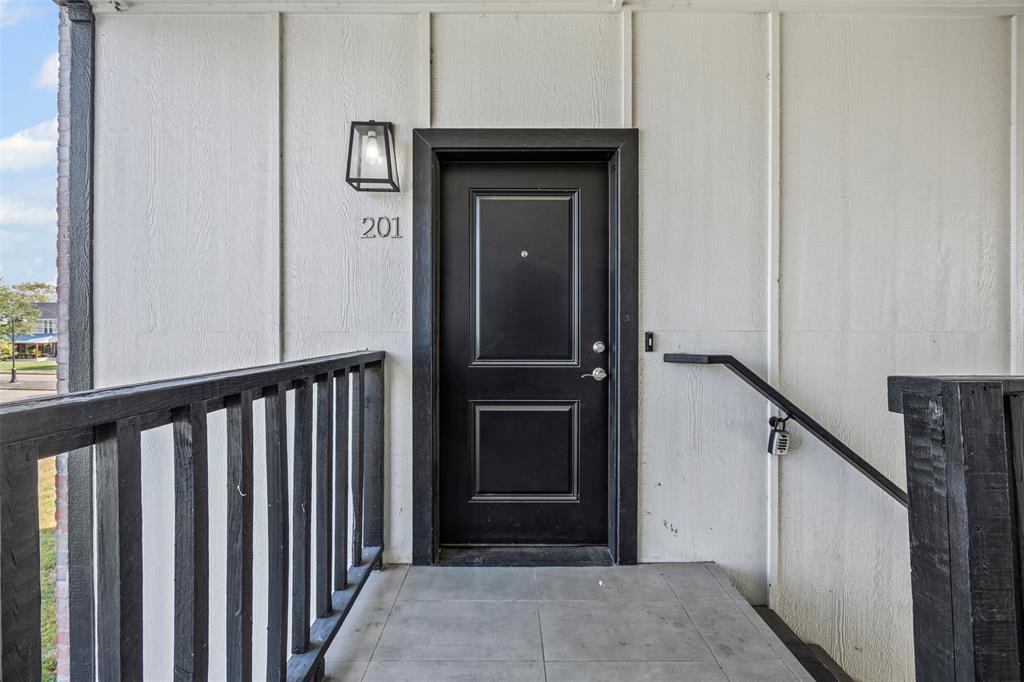 201 East 5th Street, Unit 201 Ferris, TX 75125 - Photo 8 of 19 a view of a hallway with wooden floor and staircase