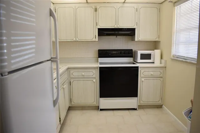 a kitchen with stainless steel appliances cabinets and a window