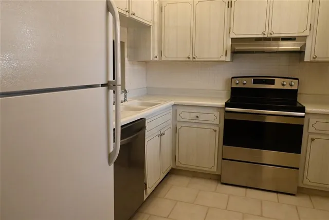 a kitchen with stainless steel appliances granite countertop a stove a refrigerator and a microwave