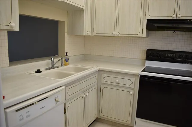 a kitchen with white cabinets and a sink