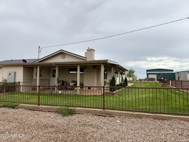 a view of a house with a yard and a large tree