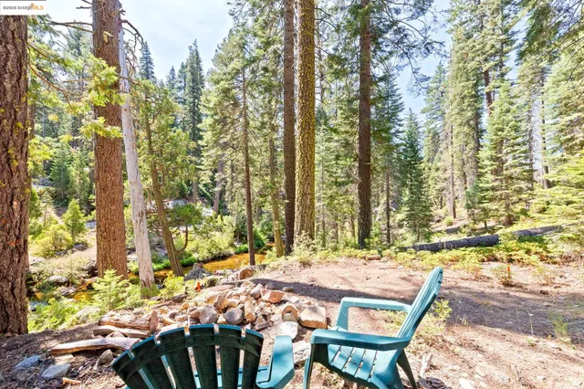 a balcony with table and chairs and wooden fence